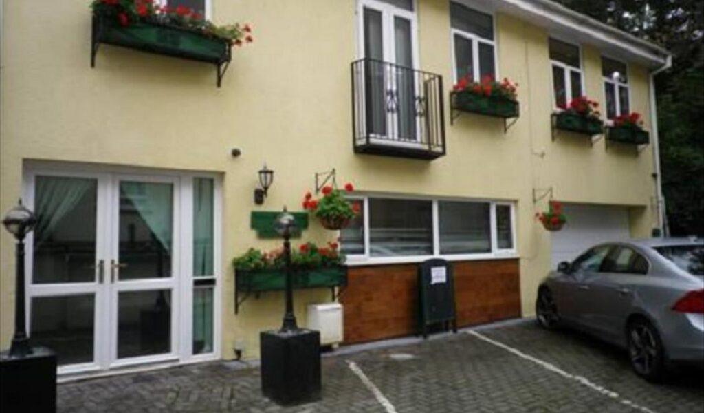 House exterior with flower boxes and a parked car
