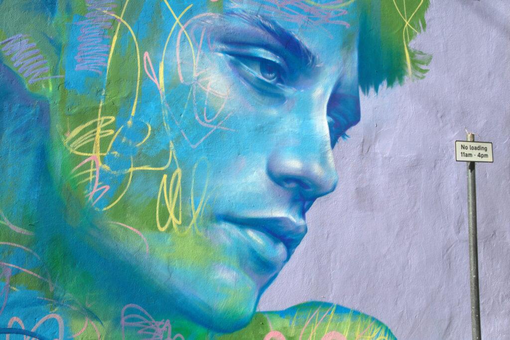 A giant face painted onto a wall next to a no loading sign in Weston-super-Mare
