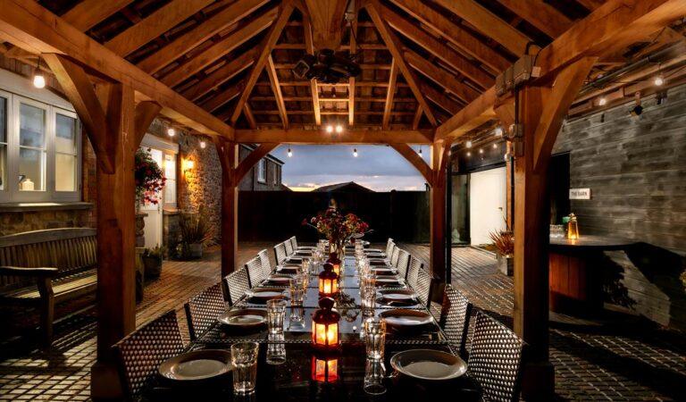 Large party barn with a big dining table set for dinner