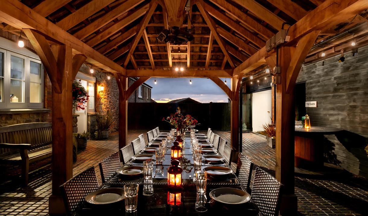 Large party barn with a big dining table set for dinner