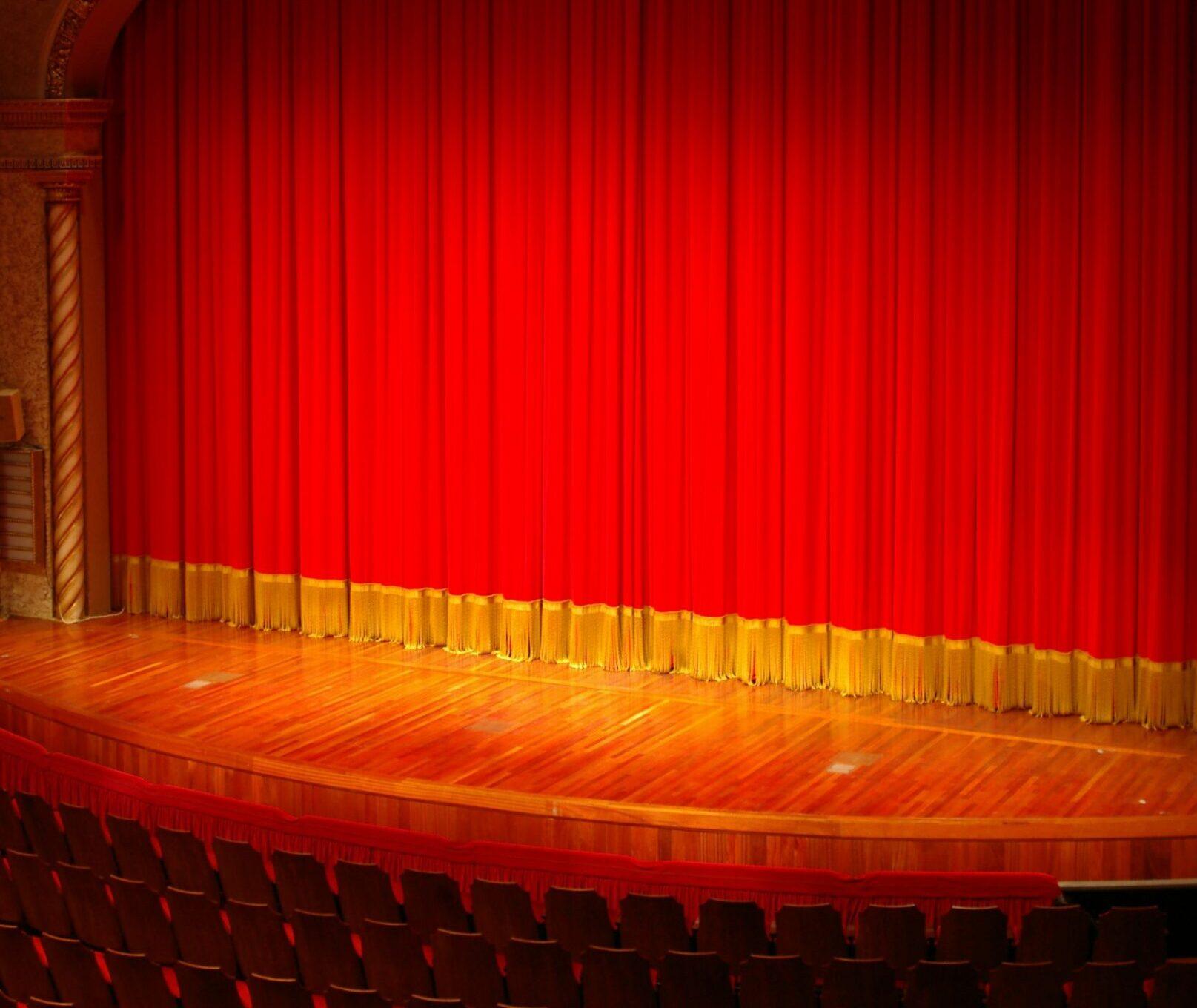 A stage curtains sits closed on a stage.