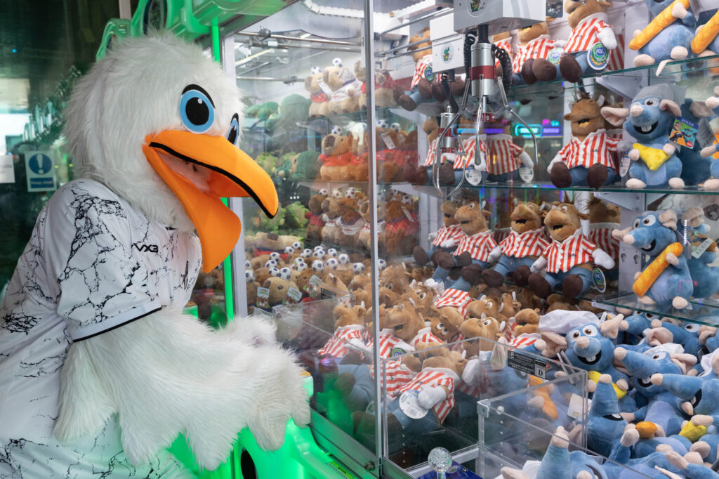 A giant seagull mascot playing an arcade game