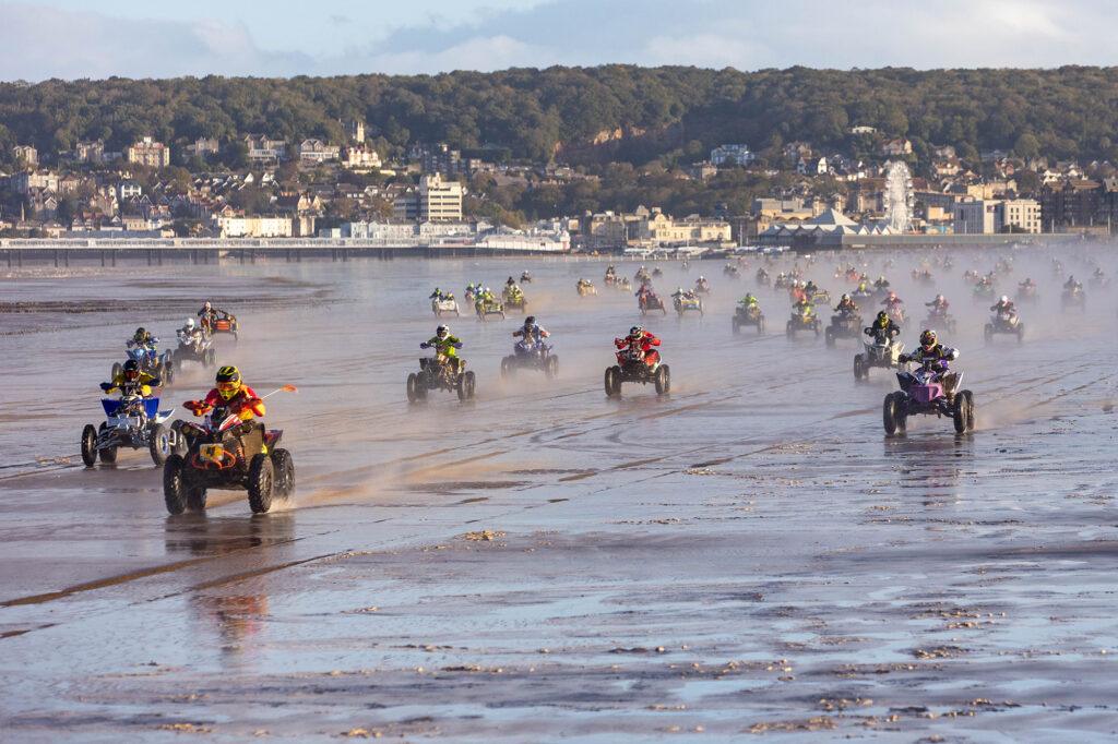 Quad bikes race along the shoreline at the start of the Weston Beach Race