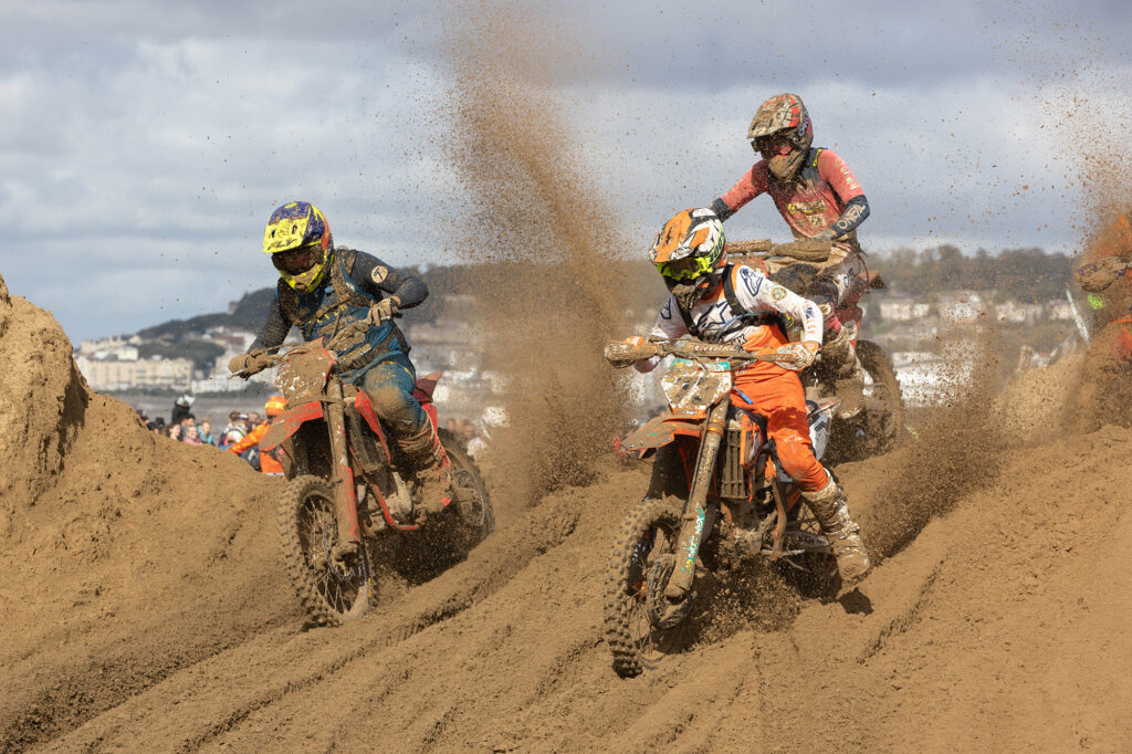 Three motorbike riders kick up a sandstorm at the Weston Beach Race