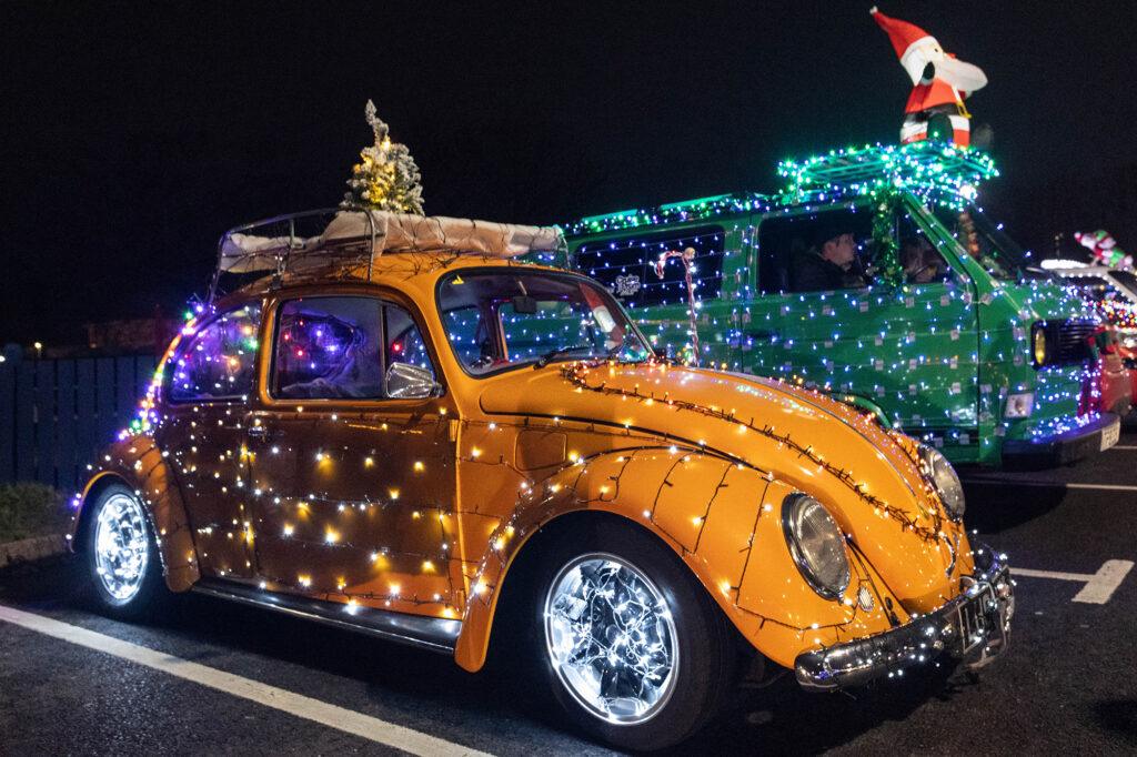 A yellow VW Beetle covered in Christmas lights during the Weston-super-Mare Vee Dubs Christmas Cruz