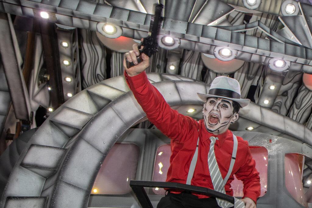 A performer at the Weston Carnival points a toy gun in the air
