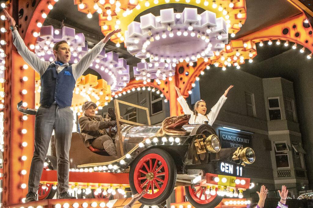 Three people on a car themed float at the Weston-super-Mare Carnival