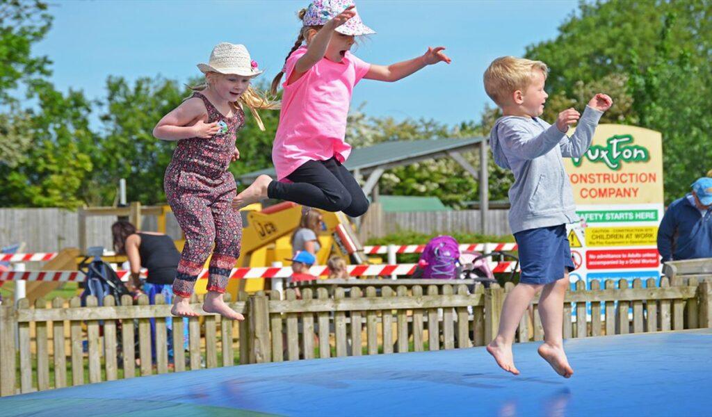 Three young children jumping at Puxton Park