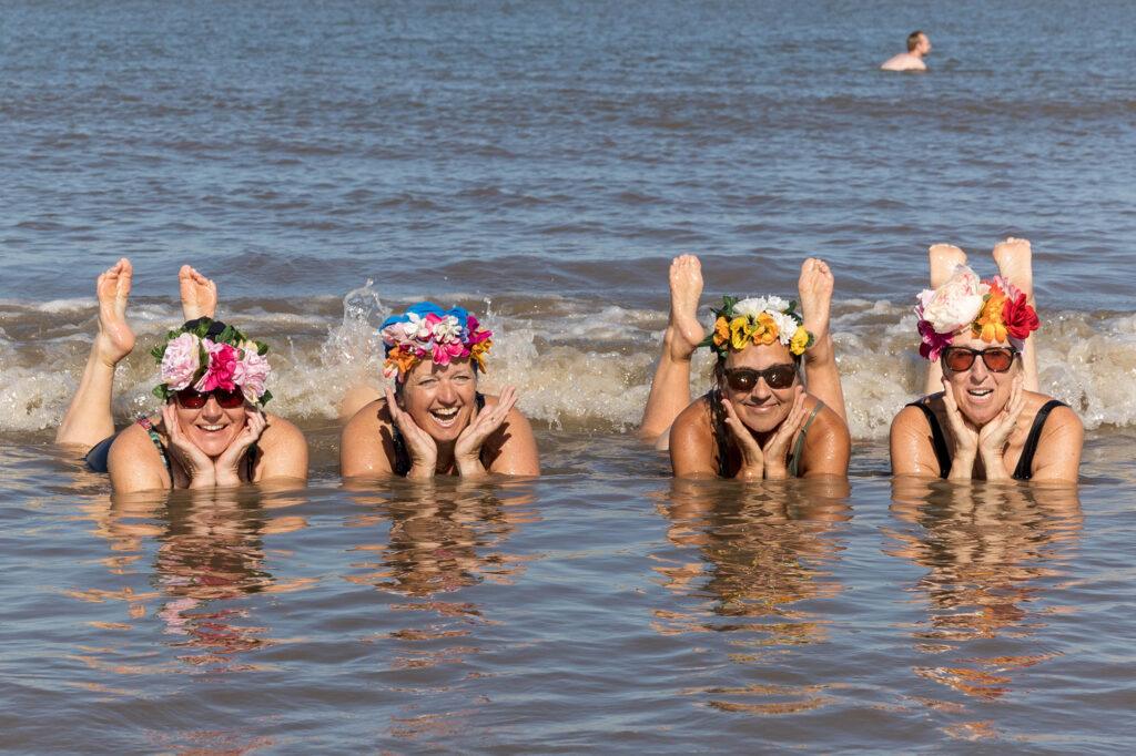 Four lady swimmers lying in the sea