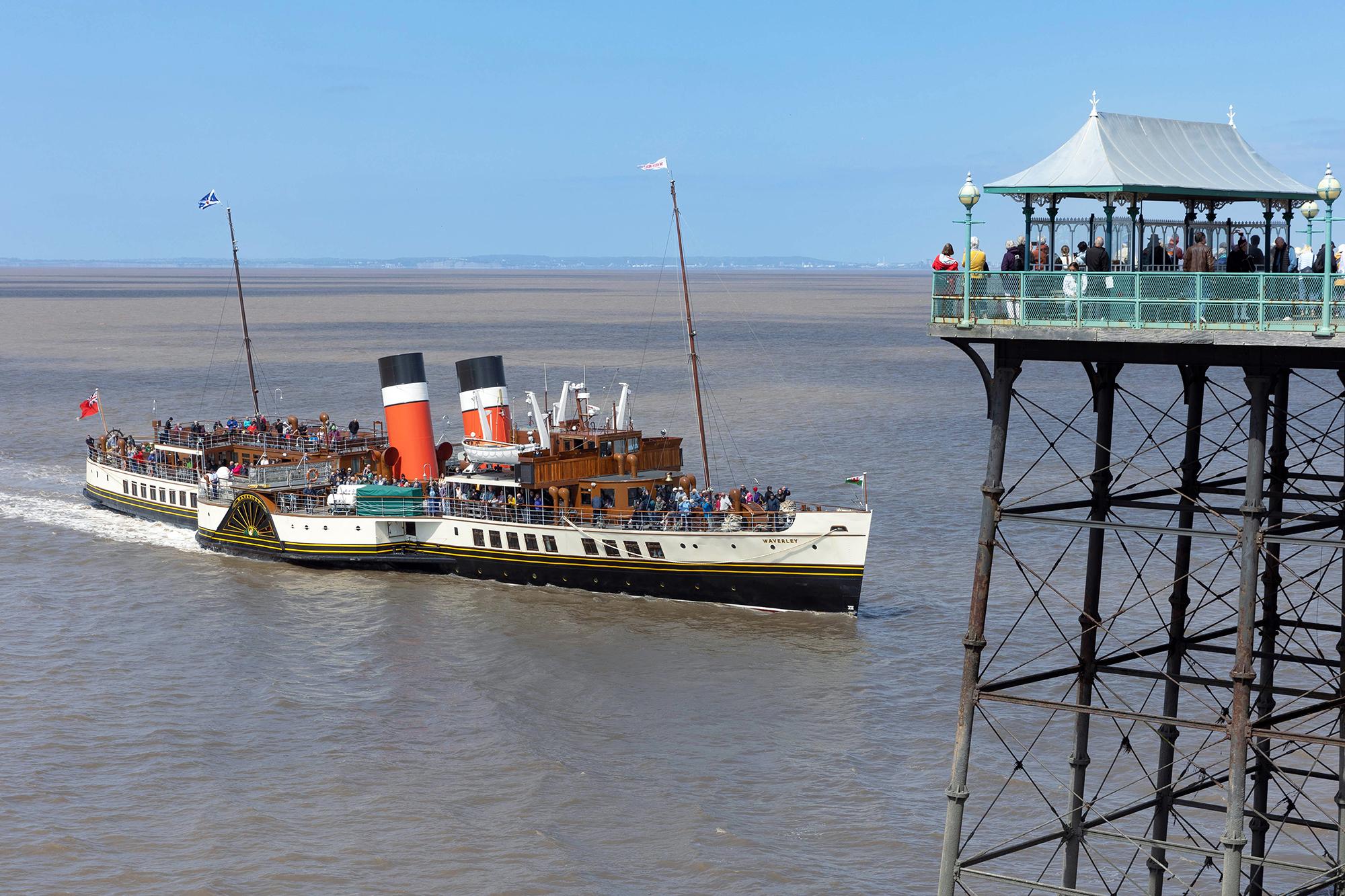 The Waverley paddle steamer coming in to dock at Clevedon Pier where passengers are waiting to board