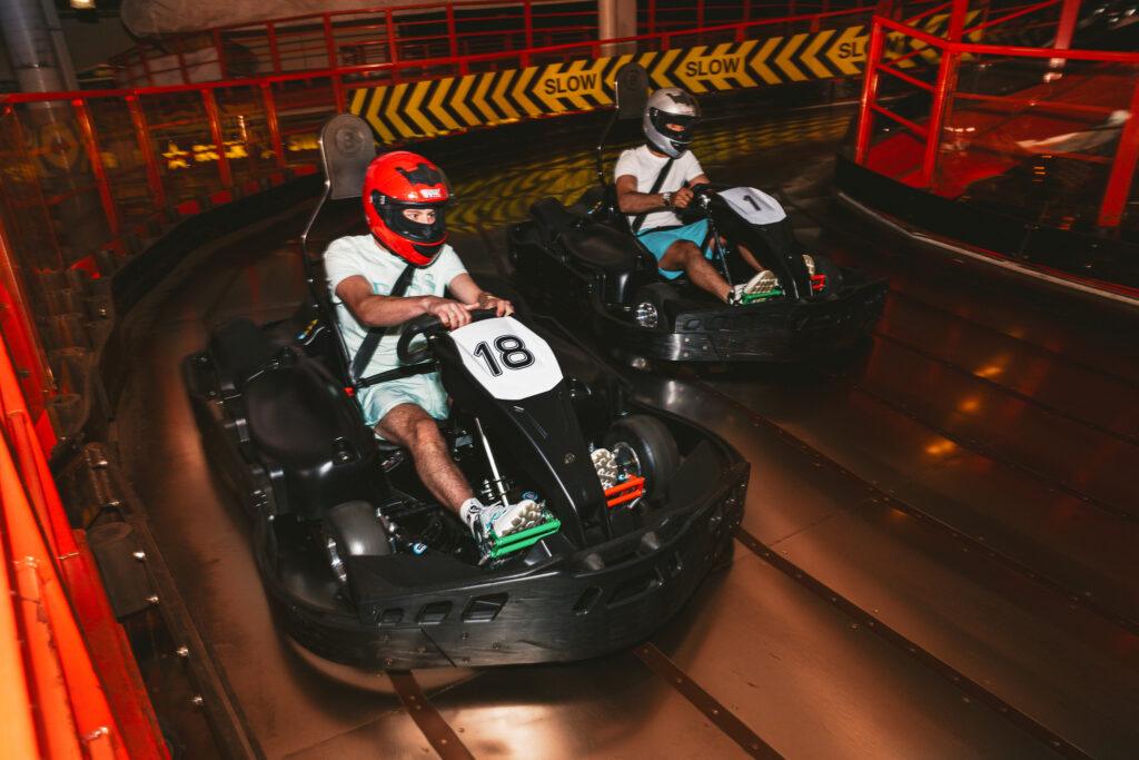 Two people in helmets racing on the indoor go-kart track on the Grand Pier, Weston-super-Mare