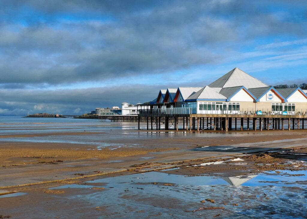 Weston-super-Mare's three piers with Revo in the foreground, The Grand Pier in the middle and Birnbeck Pier in the background
