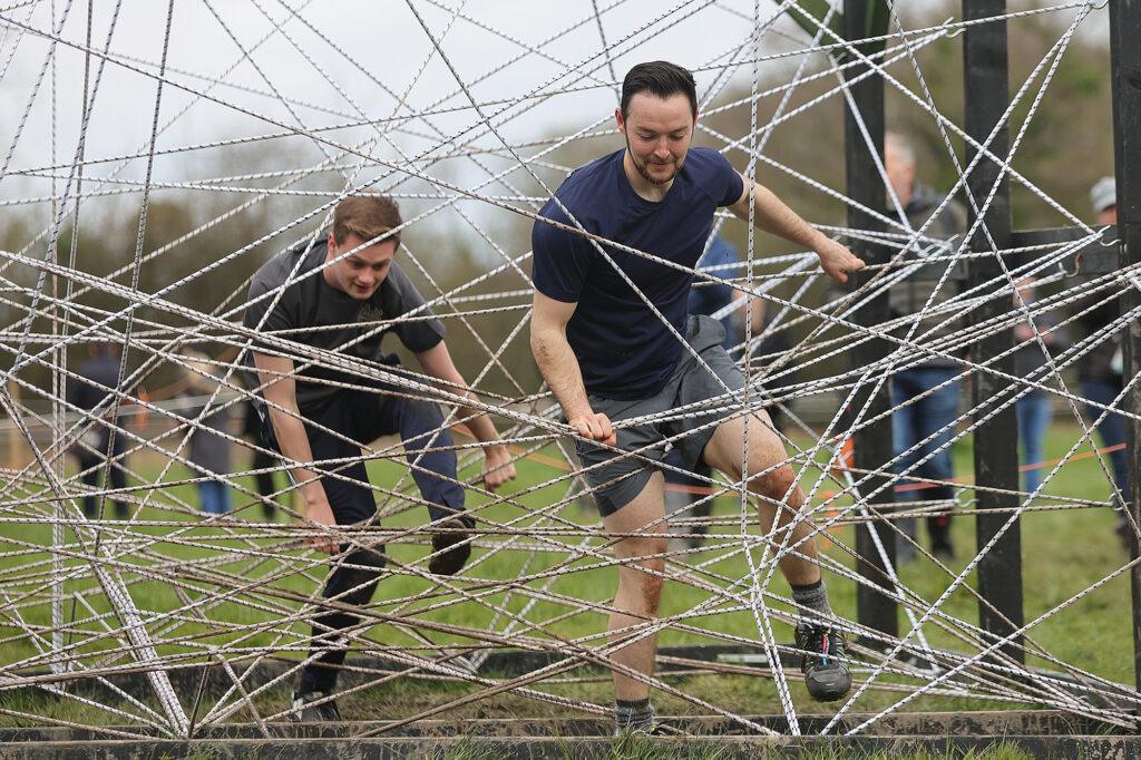 Competitors in the Puxton Park Mud Master tackling a tough rope maze