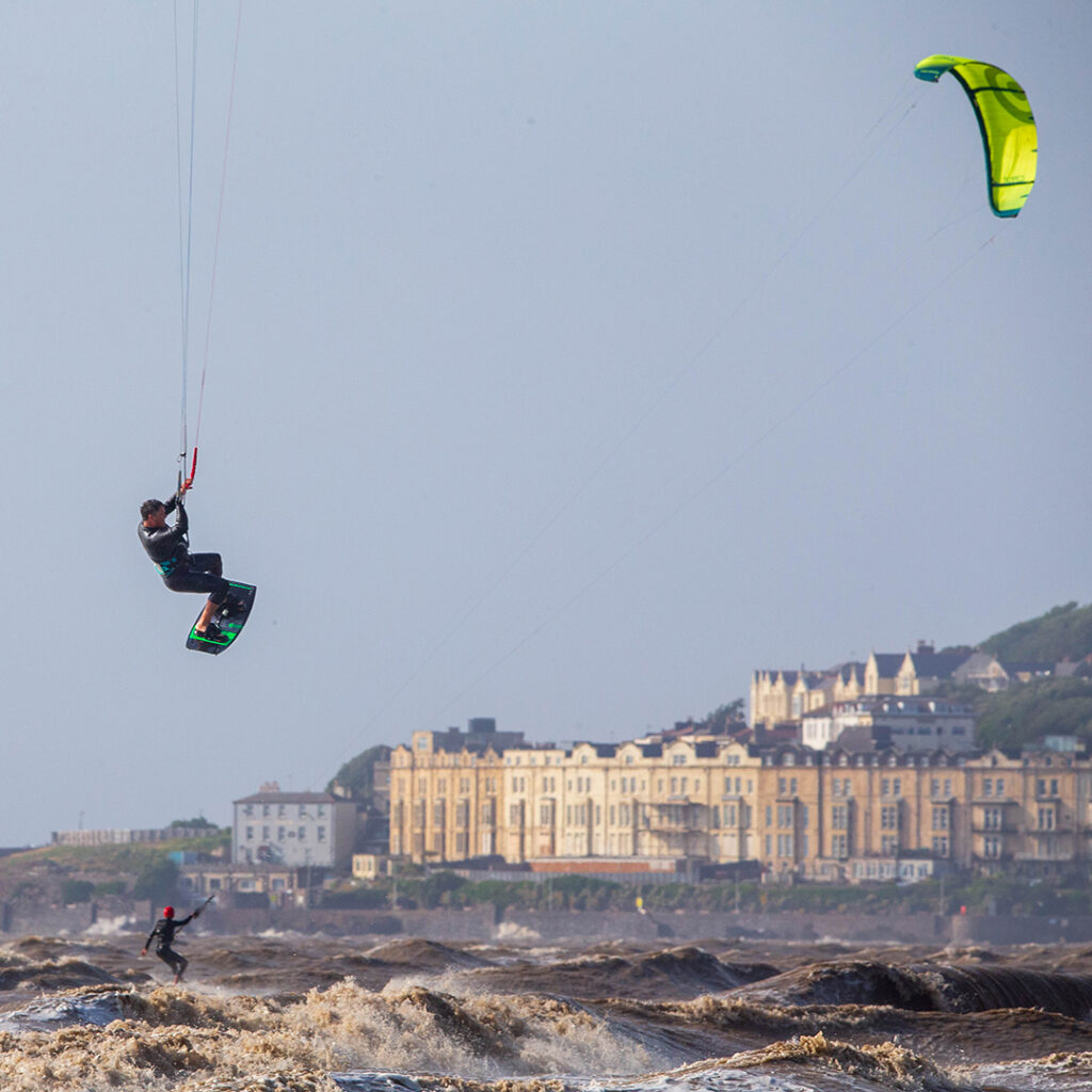 A kite surfer is lifted into the air by the wind above rough seas in Weston-super-Mare