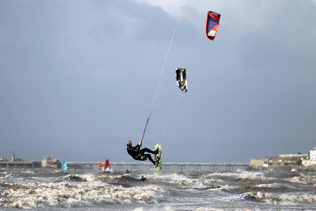 A kite surfer is suspended in mid-air during rough seas in Weston-super-Mare
