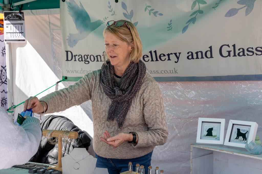 A stall holder hands over some jewellery to a customer at the Weston Weekly Market