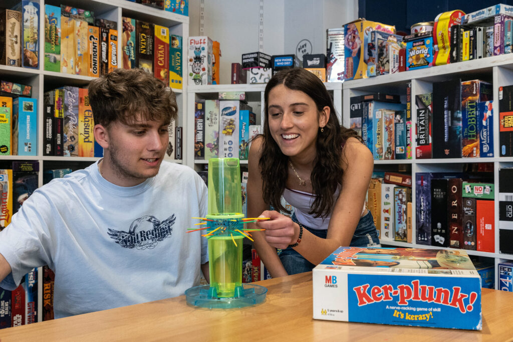 A lady carefully pulls out a straw playing Ker-plunk in the Stable Games Room, Weston-super-Mare while her playing partner, a man, looks on