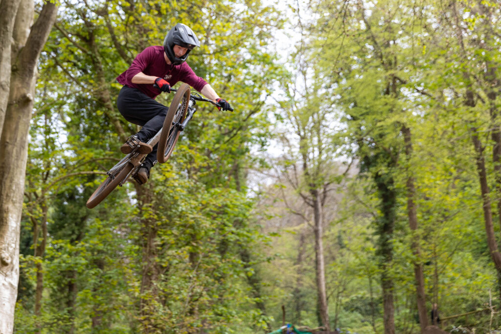 A cyclo-cross riders comes flying out of the trees while taking on the Sand Bay Dirt Jumps in Weston Woods, Weston-super-Mare.A