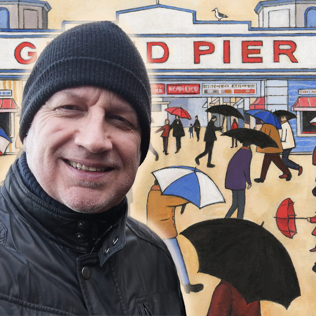 Photograph of artist Nick Roberts standing in front of one of his Lowry-inspired images