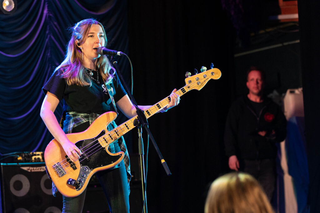A female guitarist singing on stage