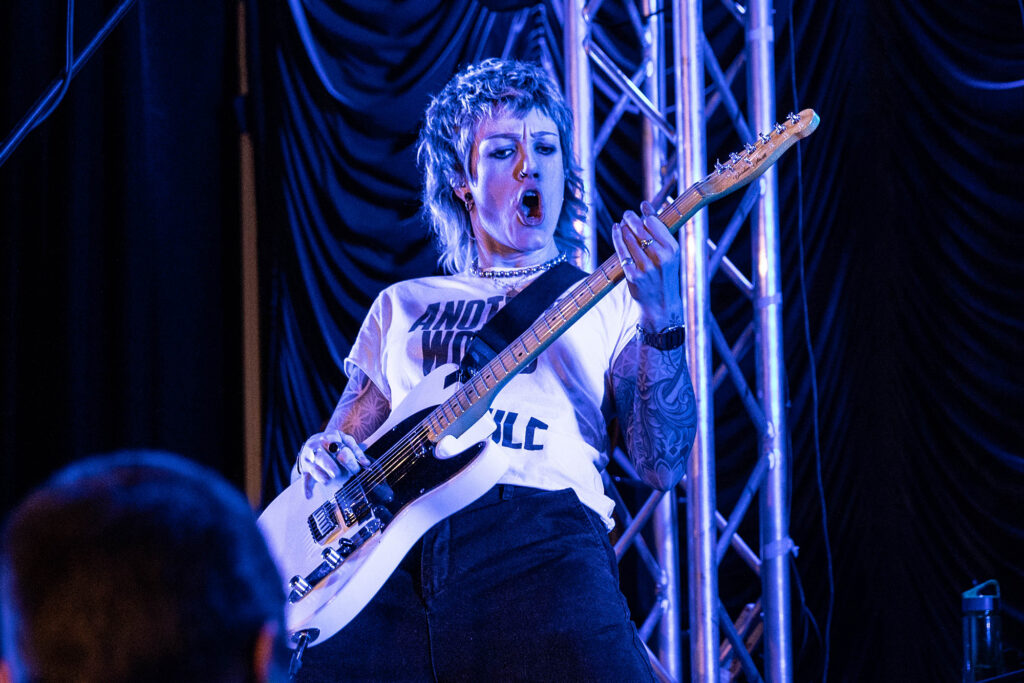 A female guitarist performing on stage