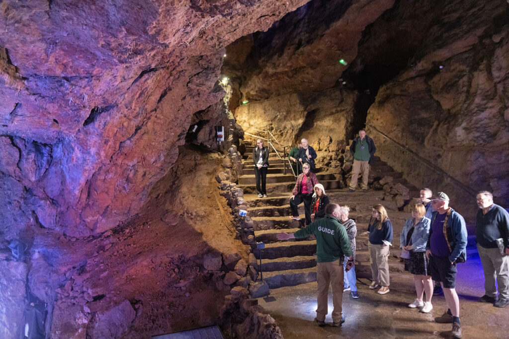 A tour guide leading people through the caves tour at Wookey Hole