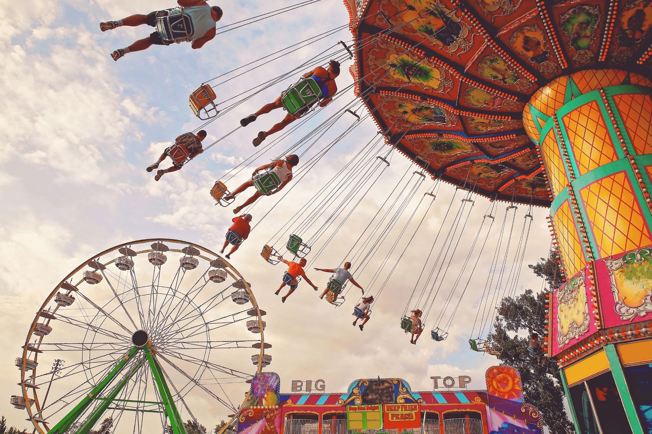 Backview of people on the swinging chairs on a fairground ride