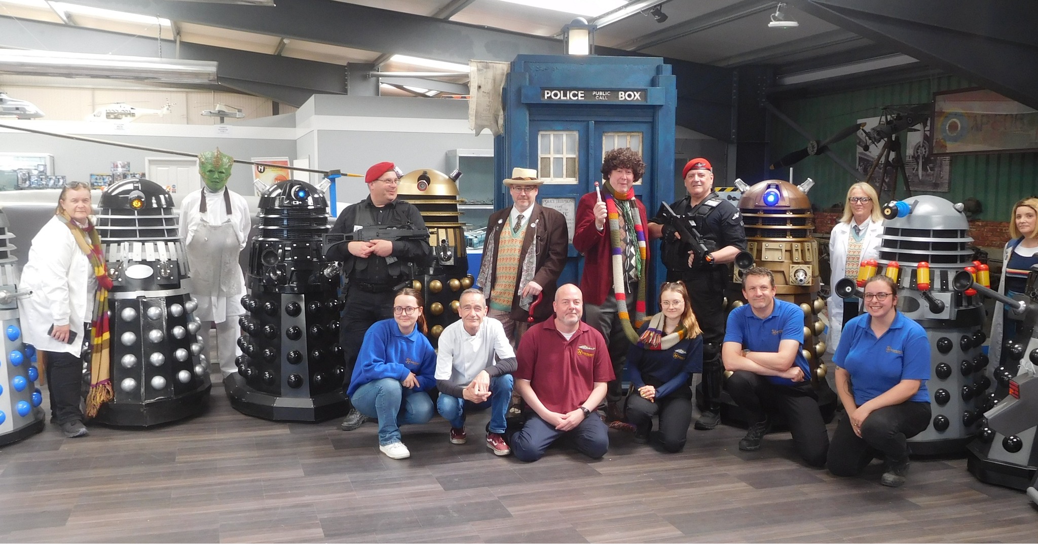 Lots of people, some dressed as daleks in front of a Dr Who Tardis