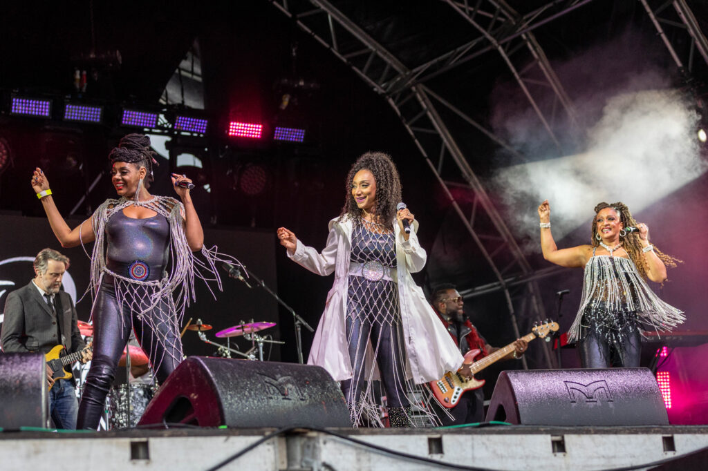 Three members of the Sister Sledge band performing on stage