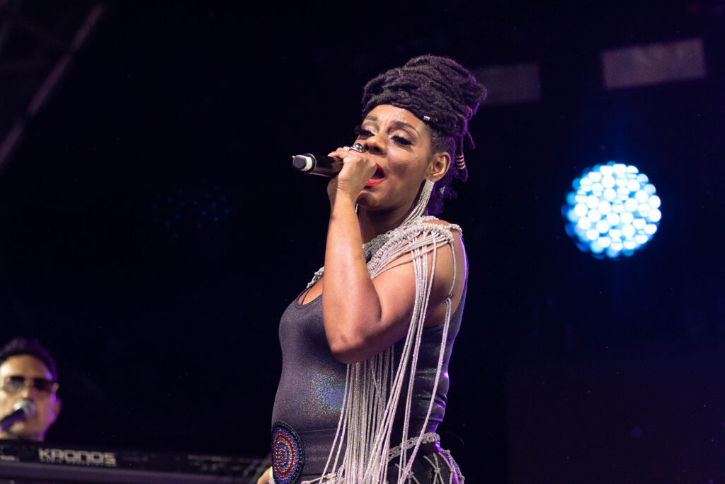 A lady sings into her microphone on stage