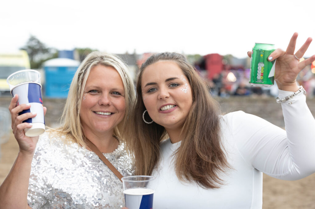 Twp ladies dressed in white and silver raise their drinks