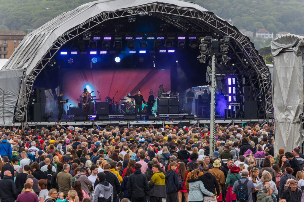 Huge festival stage with a large crowd in front of it