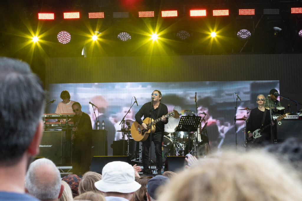 View through the head of crowd at a band performing on stage