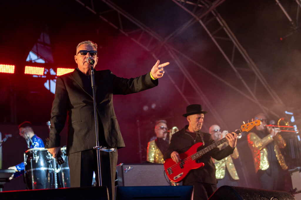 Suggs lead singer of pop band Madness point to his fellow band members