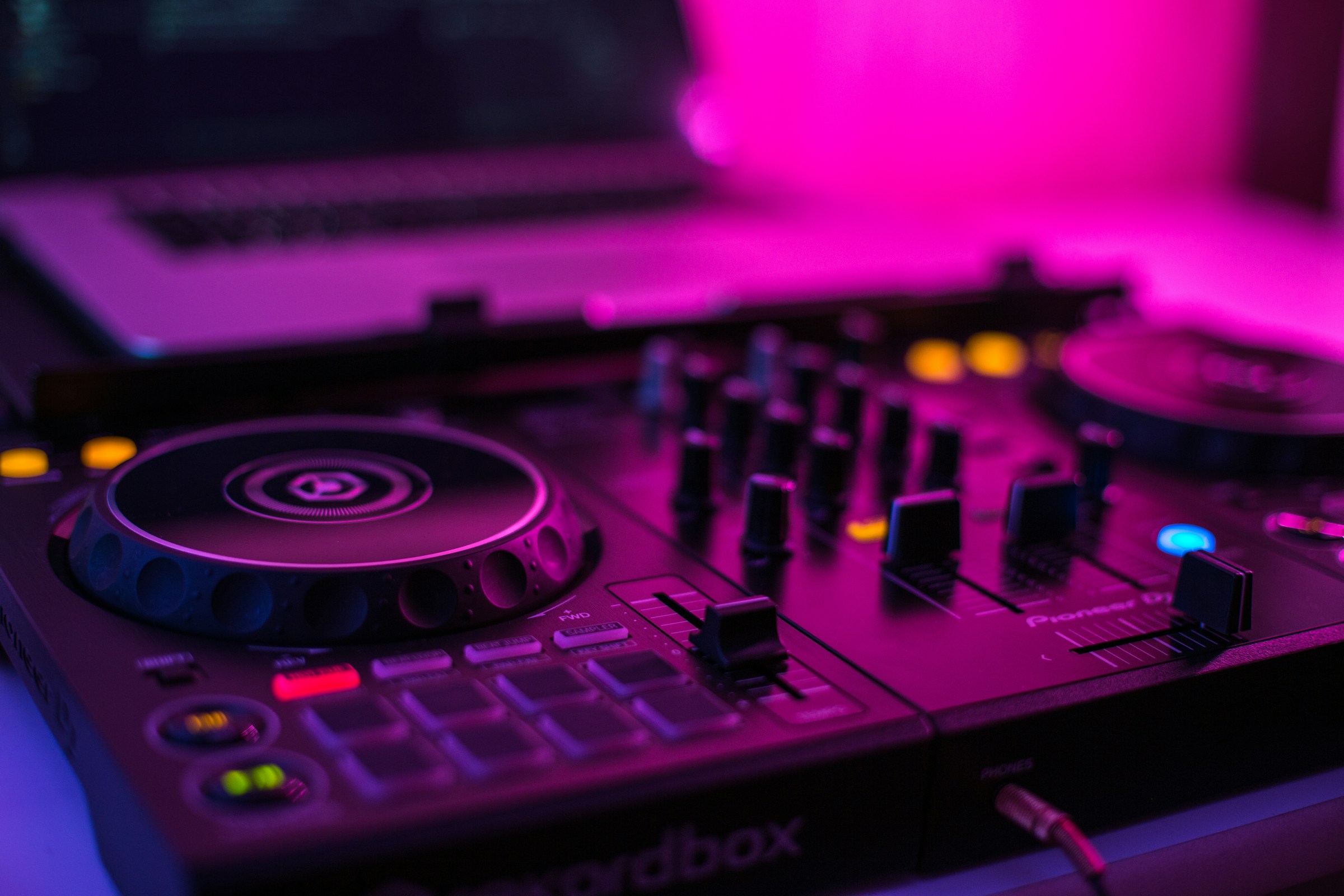 A slight top down view of a dj deck in pink lighting
