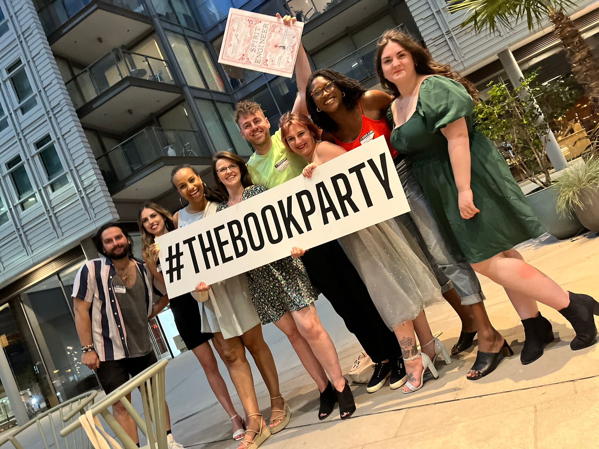A group of people hold a banner saying #TheBookParty