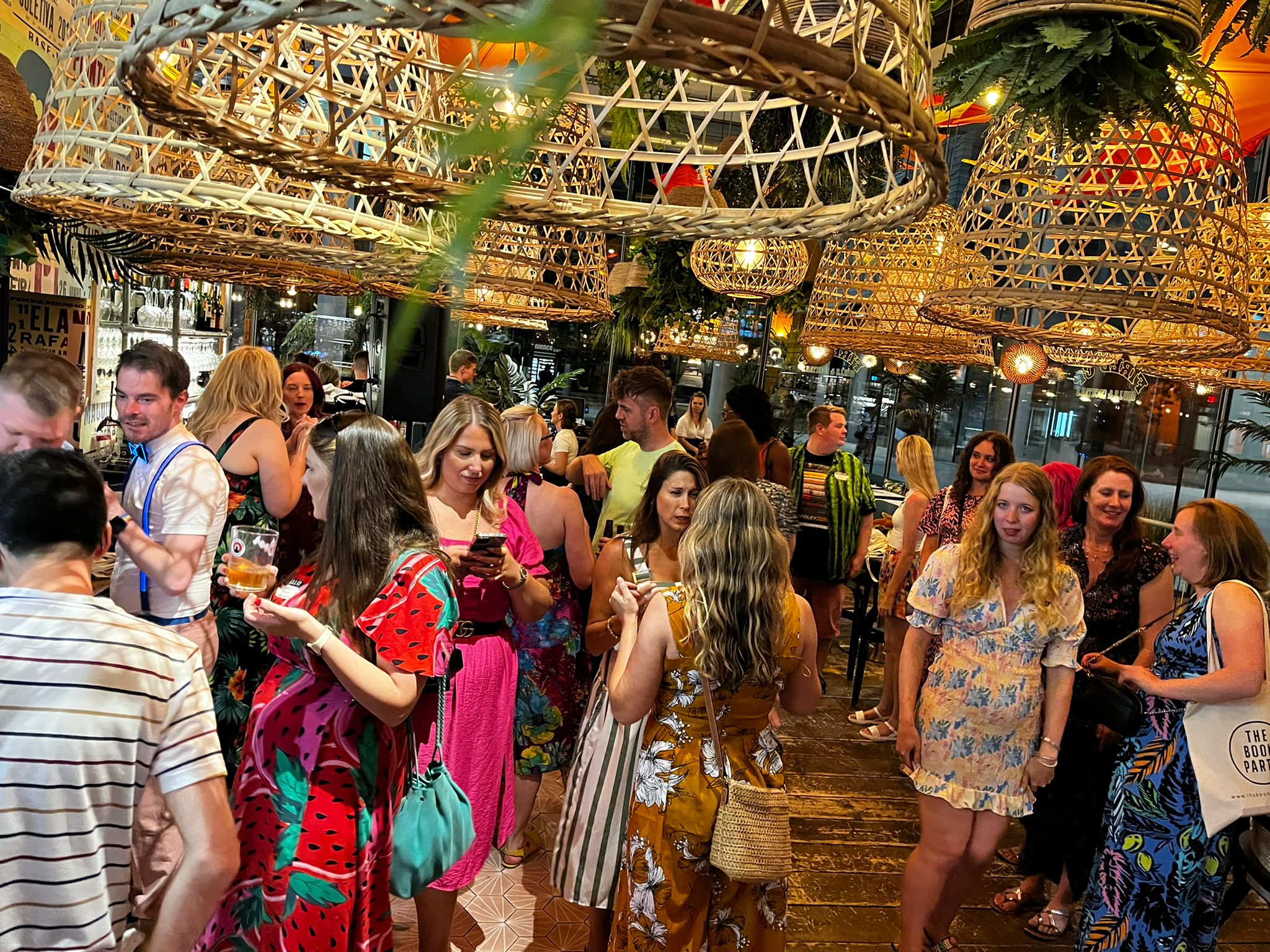 A big crowd of people inside a room with huge lampshades