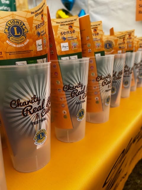 A line of cups with the Charity's branding on and tickets inside