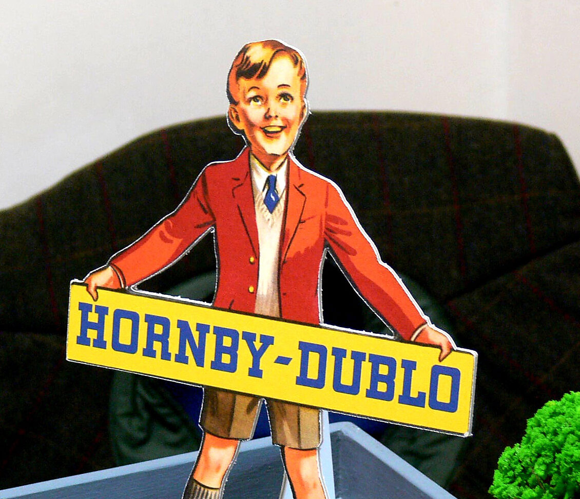 A cut out sign of a boy in a red blazer holding a 'Hornby-Dublo' sign