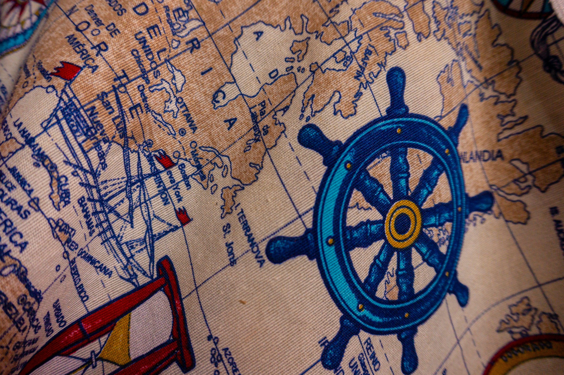 An old style pirate map with a large helm printed on it in blue