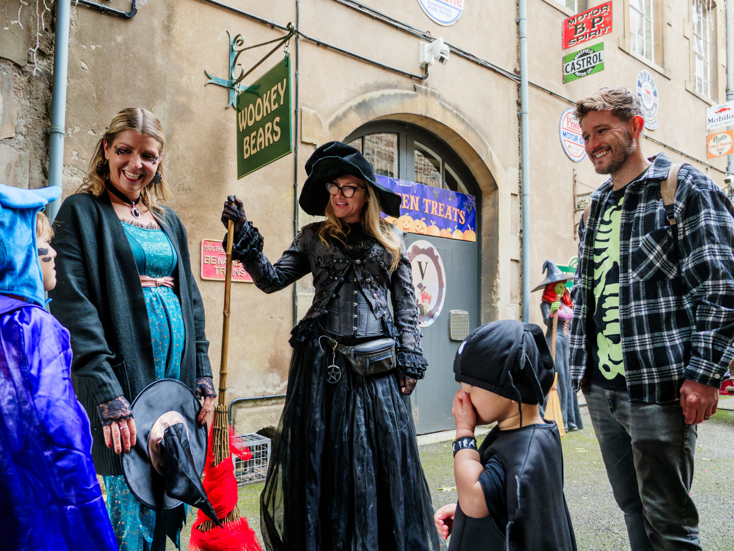 A woman dressed as a witch talks to a group of adults and children
