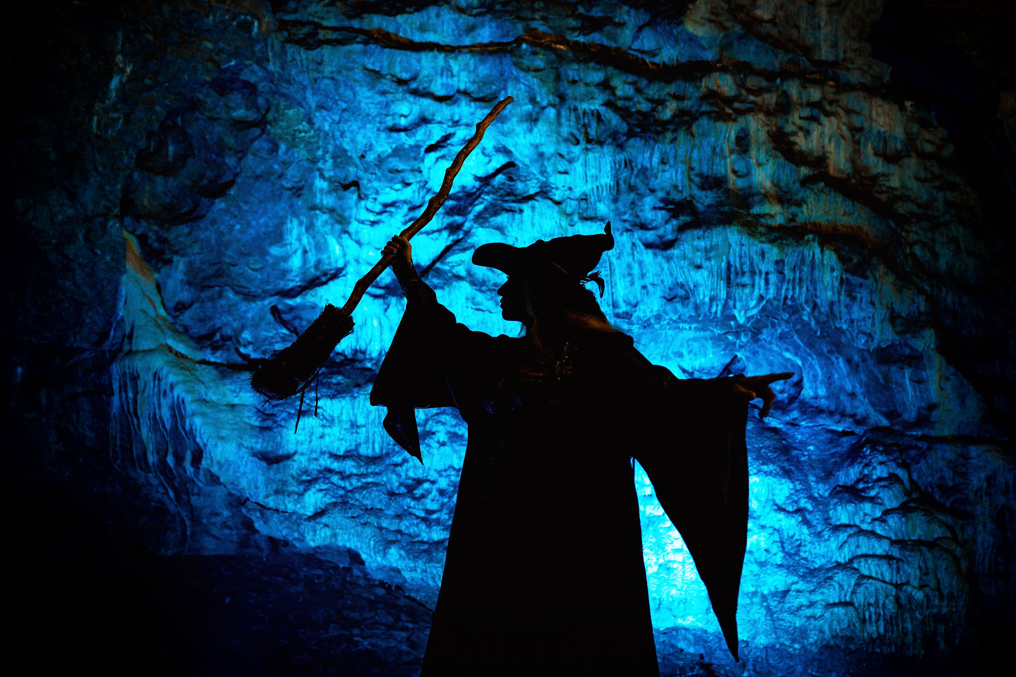 A spooky witch silhouette projected onto a cave wall